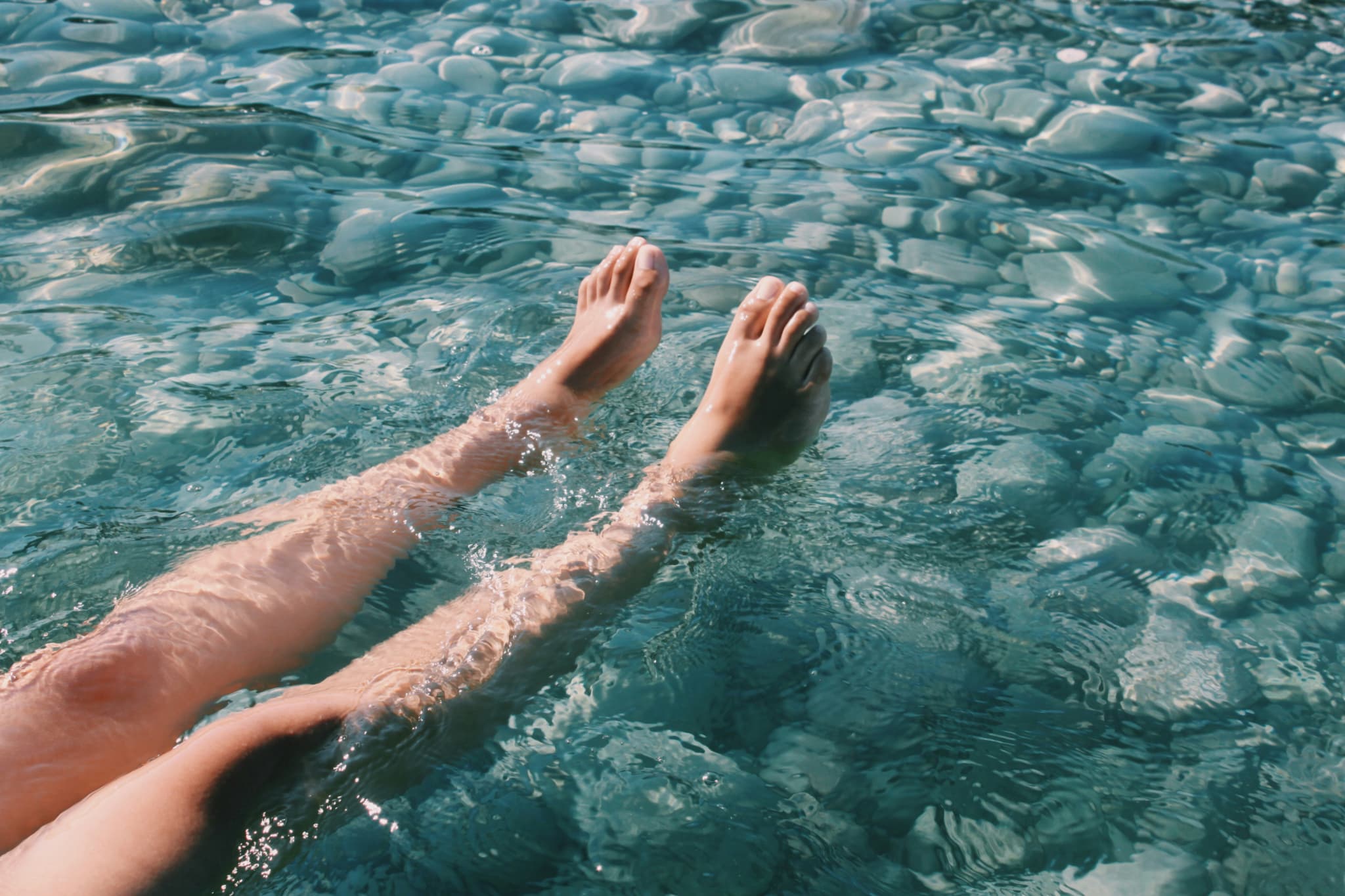 XO脚の人が水に脚をつけている様子
