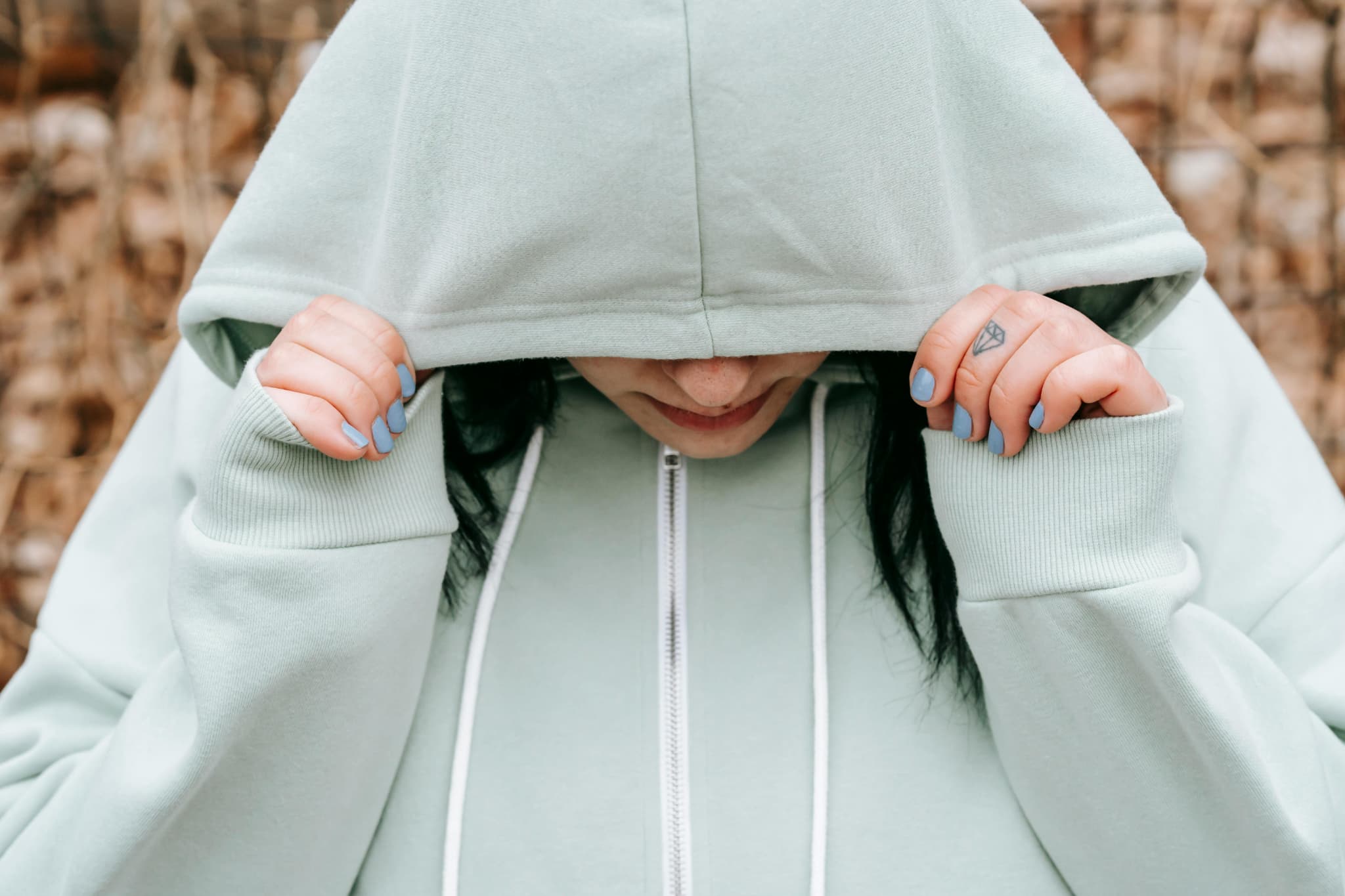 だれにも会いたくなくてフードを深く被って顔を隠している女性