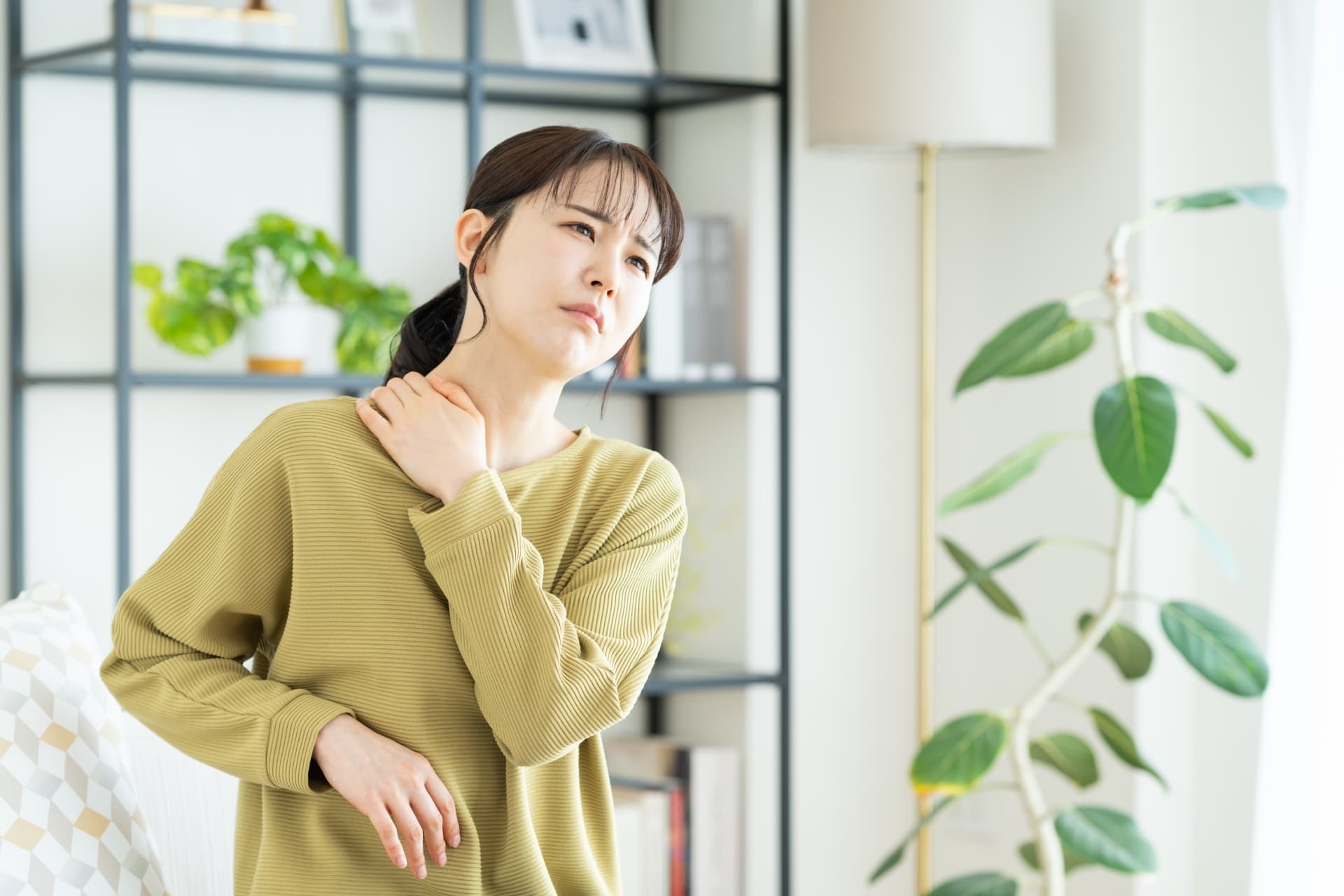 肩こりで日頃から悩んでいる女性。