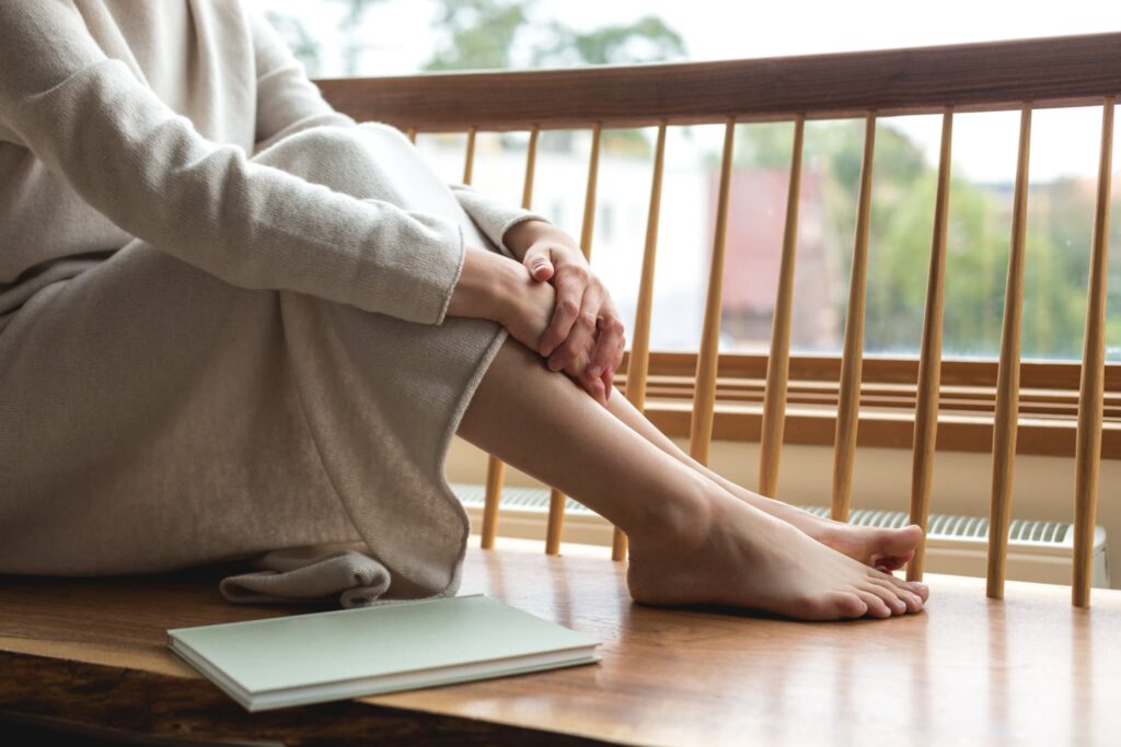 woman resting her feet by the window 1